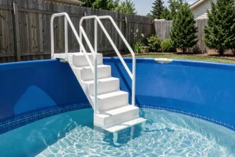 Escalier de piscine blanc posé contre la paroi d'un bassin à liner bleu